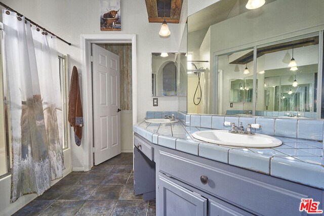 bathroom with shower / tub combo with curtain and vanity