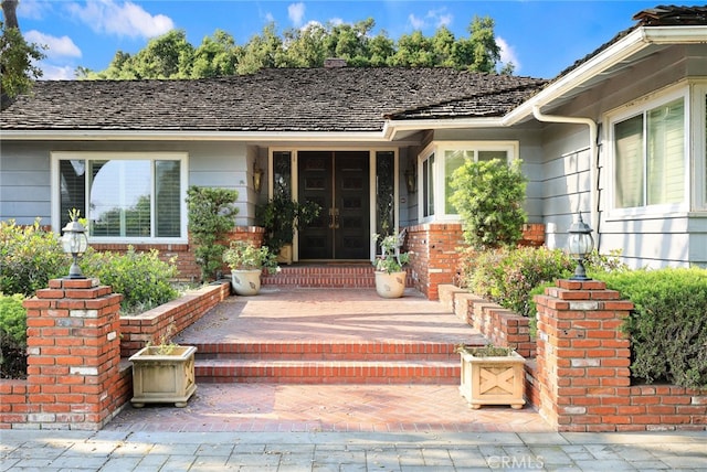 view of exterior entry with french doors and brick siding