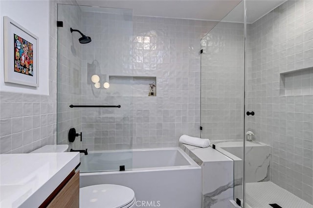 bathroom featuring toilet, vanity, and tile walls