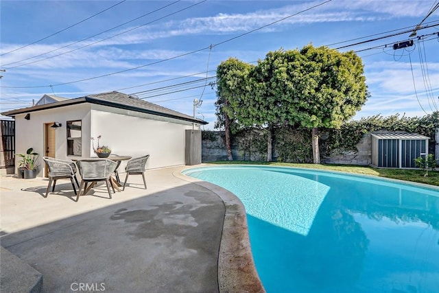 view of pool with a patio area and a shed