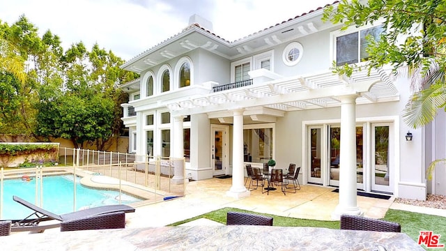 back of house with a pergola, a fenced in pool, a patio area, and french doors