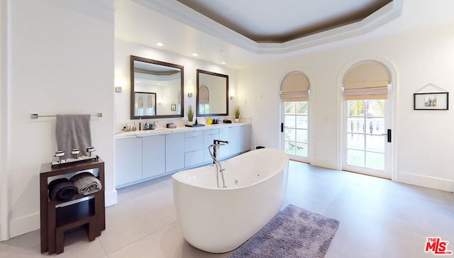 bathroom with vanity, a raised ceiling, tile patterned flooring, and a tub