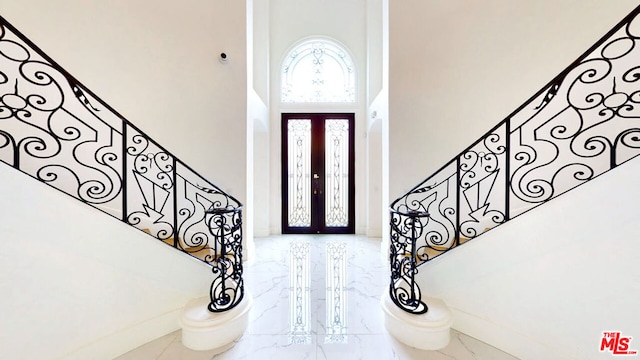 foyer with a towering ceiling and french doors