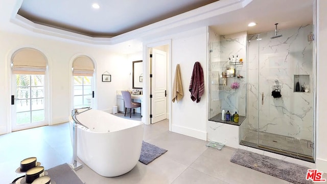 bathroom featuring shower with separate bathtub and a raised ceiling