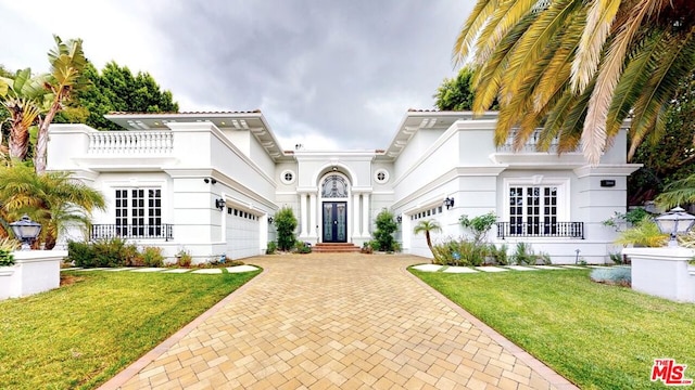 mediterranean / spanish home featuring a front lawn and a garage