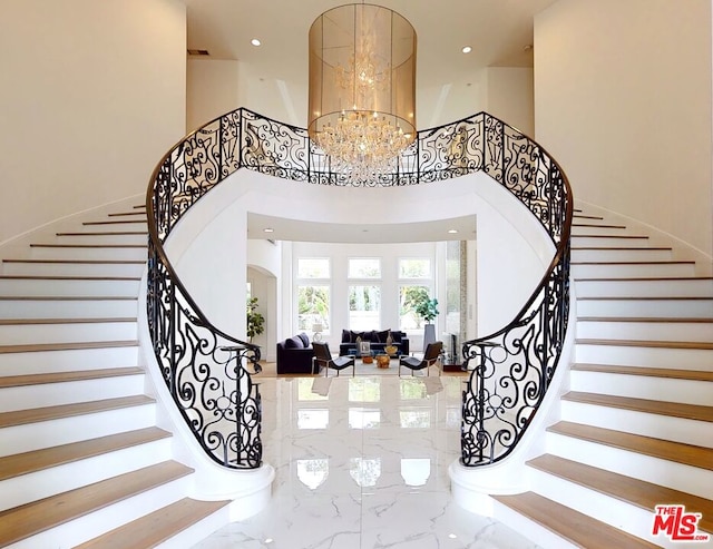 foyer with a towering ceiling and a chandelier