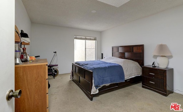 bedroom featuring light colored carpet and a textured ceiling