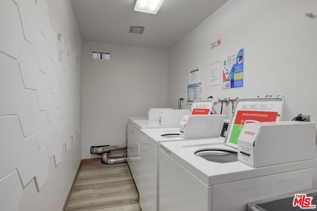 laundry room with independent washer and dryer and light hardwood / wood-style flooring