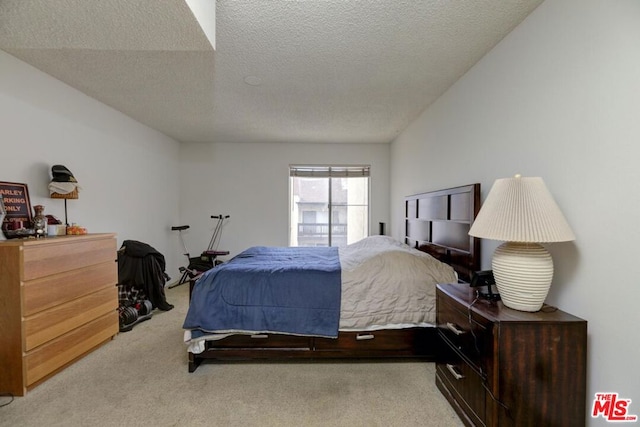 bedroom featuring a textured ceiling and light carpet