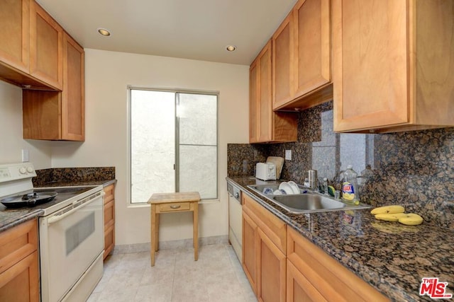 kitchen with sink, dark stone counters, white appliances, decorative backsplash, and light tile patterned floors