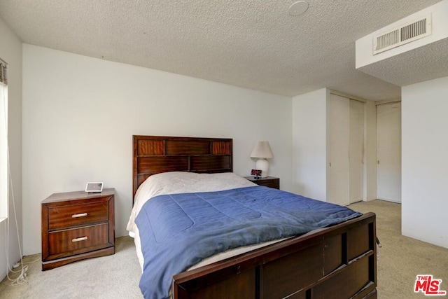 carpeted bedroom featuring a textured ceiling