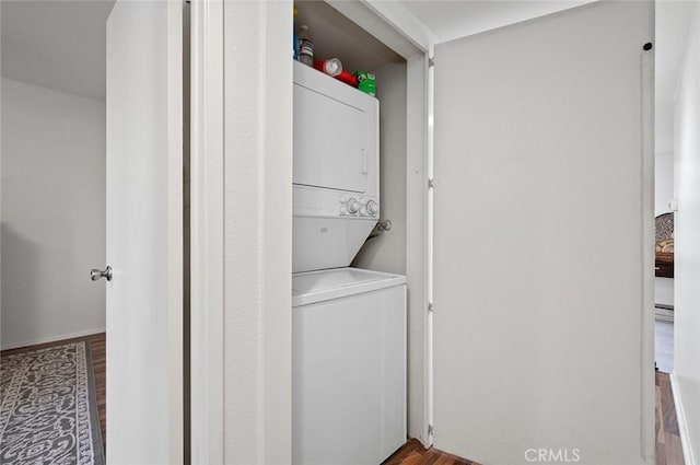 laundry area with wood-type flooring and stacked washer and dryer