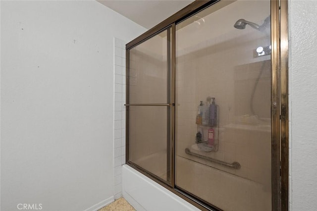 bathroom with shower / bath combination with glass door