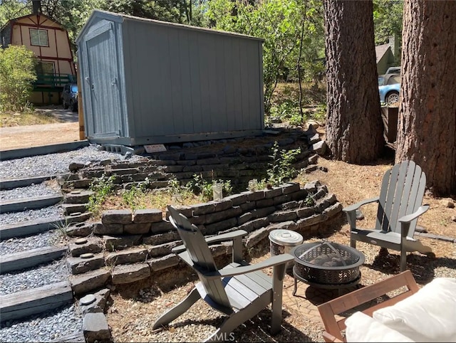 view of yard featuring a fire pit and a storage shed