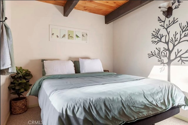 bedroom with beamed ceiling, wood ceiling, and carpet