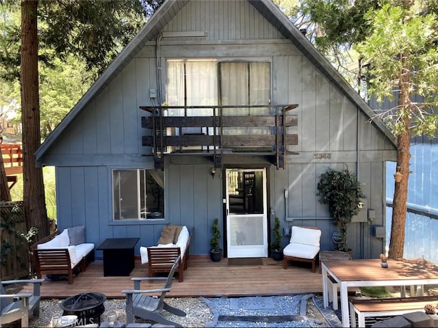 back of house featuring a wooden deck and an outdoor fire pit