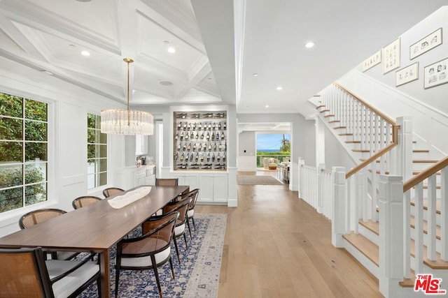 dining space with a wealth of natural light, beamed ceiling, light hardwood / wood-style floors, and coffered ceiling