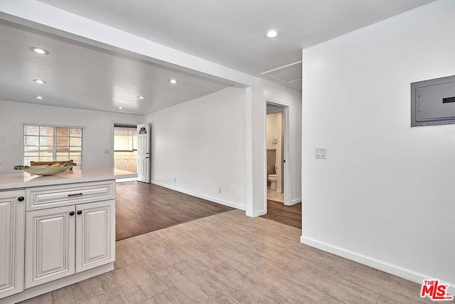 unfurnished living room featuring electric panel and light wood-type flooring