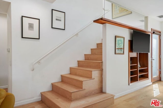 stairs featuring hardwood / wood-style flooring