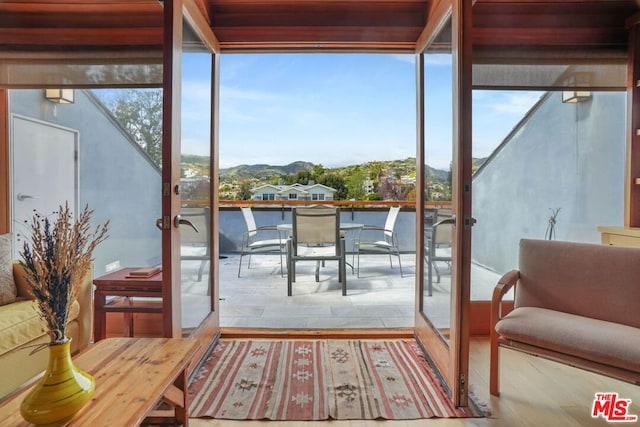 sunroom with french doors, a mountain view, and a wealth of natural light