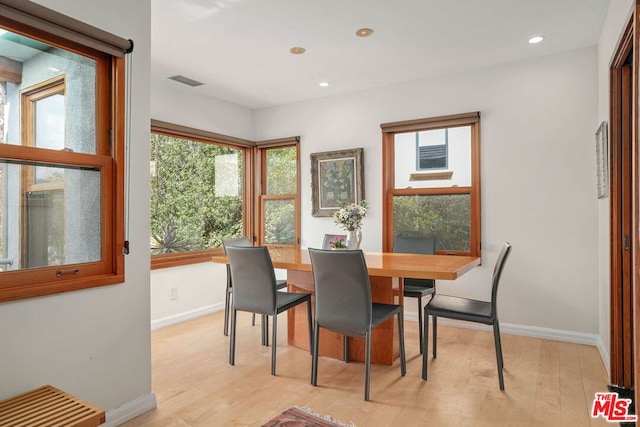 dining room with light hardwood / wood-style flooring and a healthy amount of sunlight