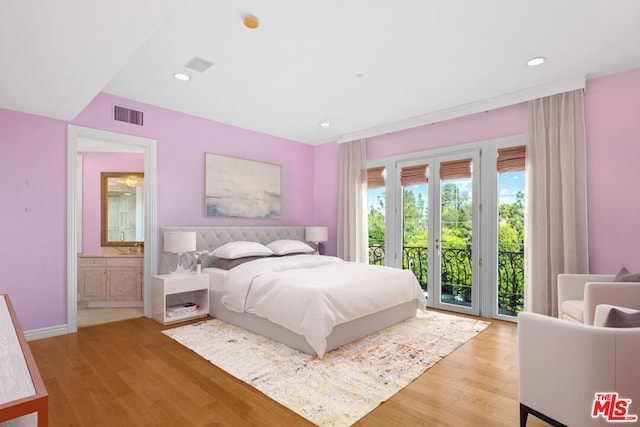 bedroom featuring light hardwood / wood-style flooring, connected bathroom, and access to exterior