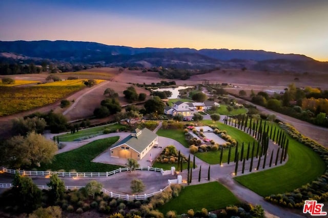 aerial view at dusk featuring a mountain view