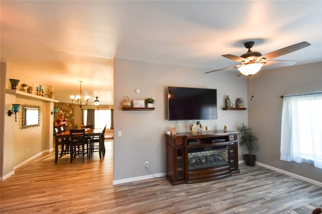 living room with wood-type flooring and ceiling fan with notable chandelier