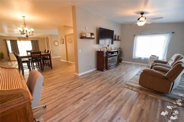 living room featuring ceiling fan with notable chandelier, hardwood / wood-style floors, and lofted ceiling