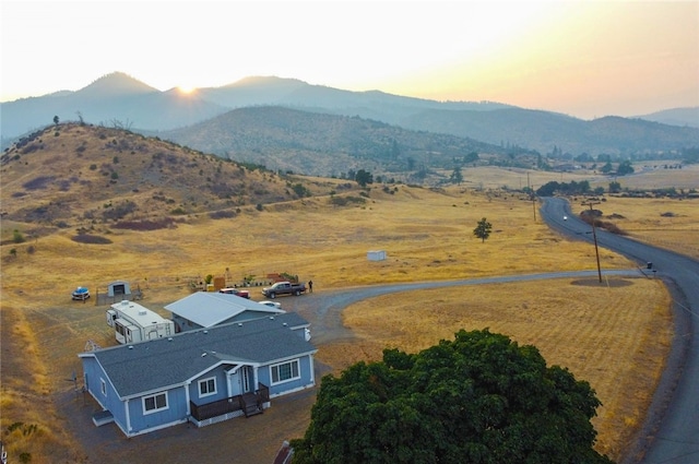 aerial view at dusk with a mountain view and a rural view