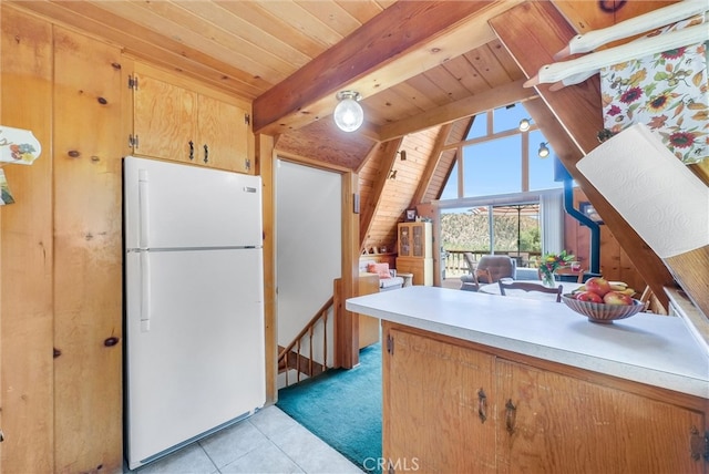 kitchen with light tile patterned flooring, white fridge, vaulted ceiling with beams, and wood ceiling