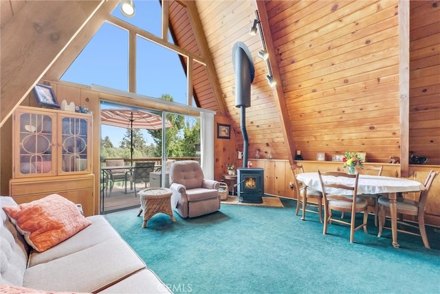 interior space featuring a wood stove, wood ceiling, lofted ceiling with beams, and a healthy amount of sunlight