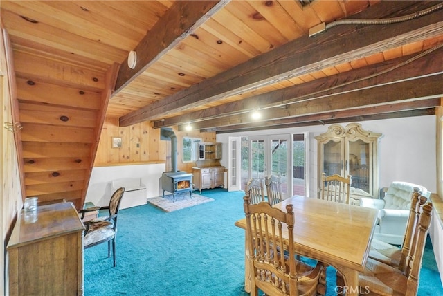 dining room with french doors, a wood stove, wooden ceiling, beam ceiling, and carpet