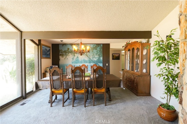 dining space with a chandelier, a textured ceiling, and carpet flooring