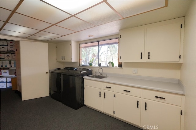 kitchen featuring separate washer and dryer, sink, dark colored carpet, and white cabinets