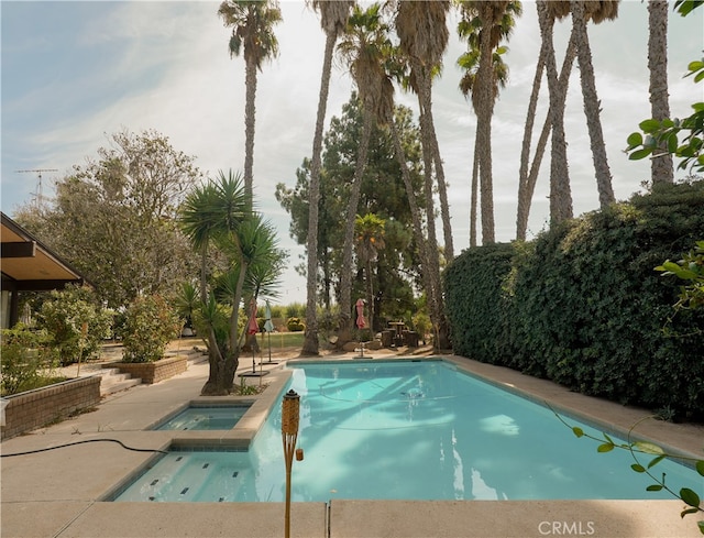 view of swimming pool featuring a patio and an in ground hot tub