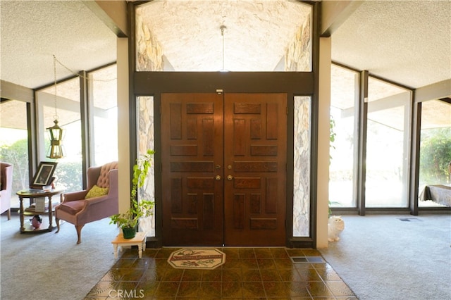 carpeted foyer entrance featuring a textured ceiling