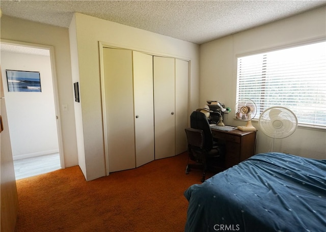 bedroom featuring dark colored carpet, a closet, and a textured ceiling