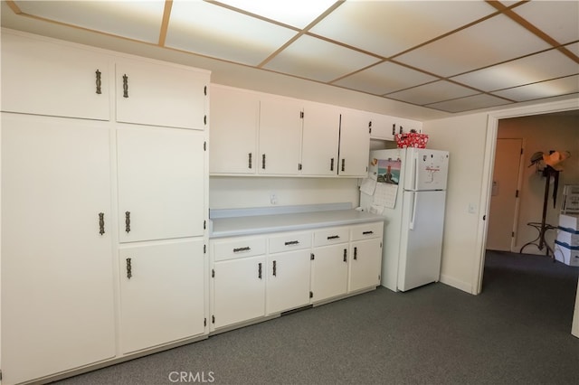 kitchen featuring white cabinetry, dark carpet, and white refrigerator