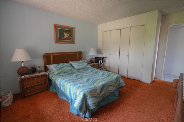 carpeted bedroom with a textured ceiling and a closet