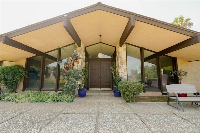 view of exterior entry with a patio