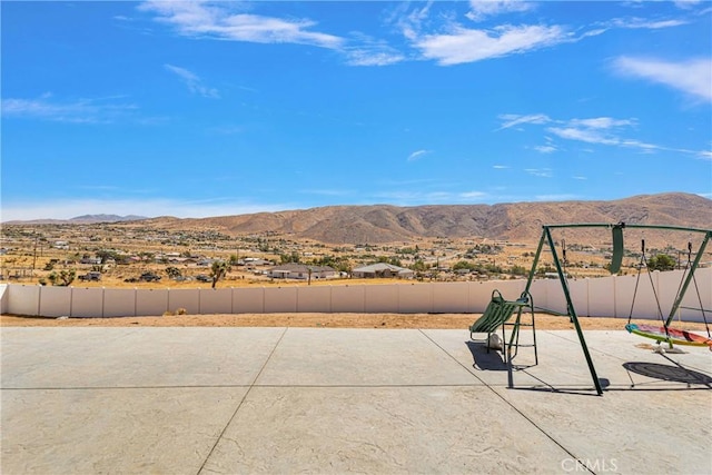 view of patio / terrace featuring a playground and a mountain view