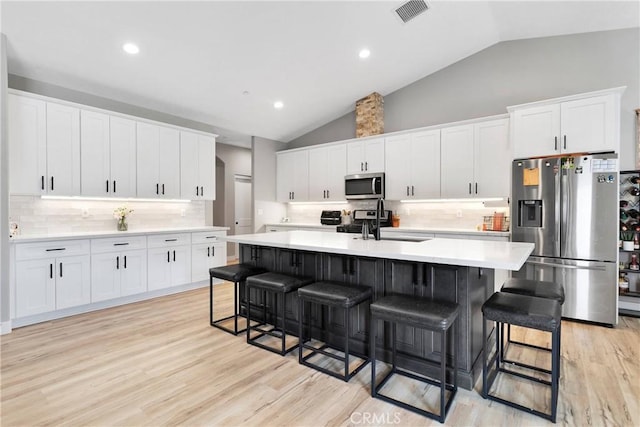 kitchen with white cabinets, backsplash, and stainless steel appliances