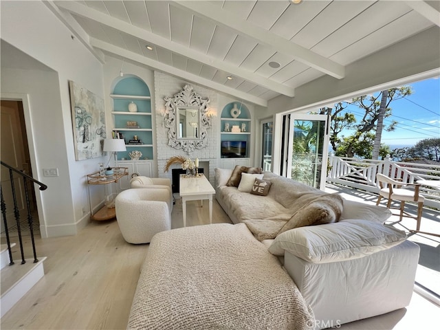 living room featuring vaulted ceiling with beams, built in features, light hardwood / wood-style floors, and a healthy amount of sunlight