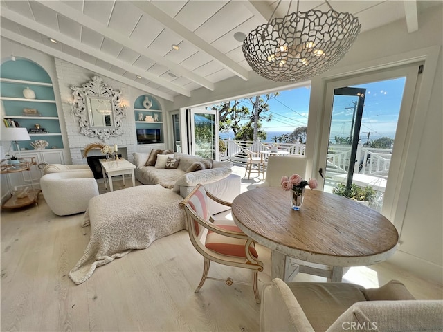 dining room featuring light hardwood / wood-style flooring, lofted ceiling with beams, and built in features