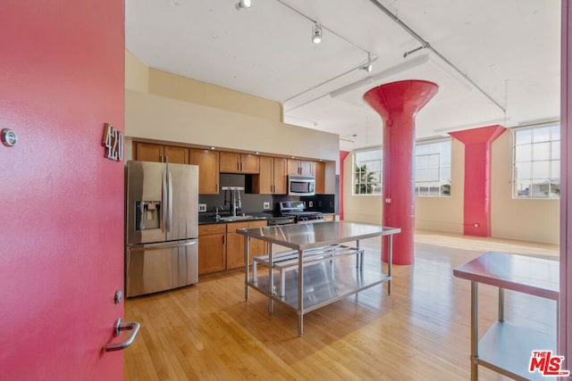 kitchen featuring light hardwood / wood-style floors, stainless steel appliances, plenty of natural light, and sink