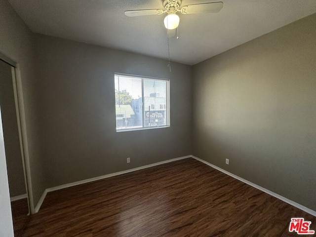 spare room with dark hardwood / wood-style flooring and ceiling fan