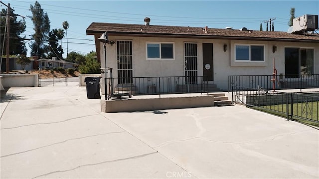 view of front of house with a patio area and central air condition unit