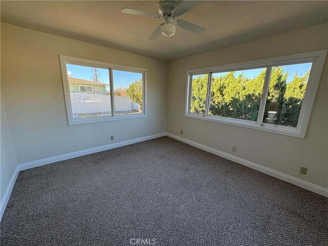 empty room featuring ceiling fan and dark carpet