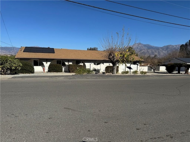 view of front facade with solar panels and a mountain view